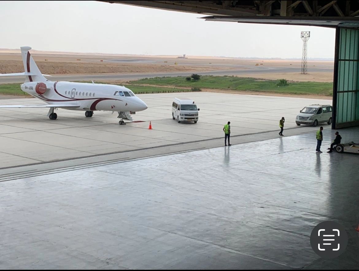 Business jet in front of the hangar with ground crew